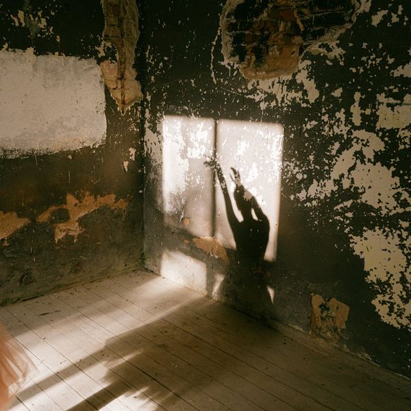 Person stretching gently in a bright, sunlit room.